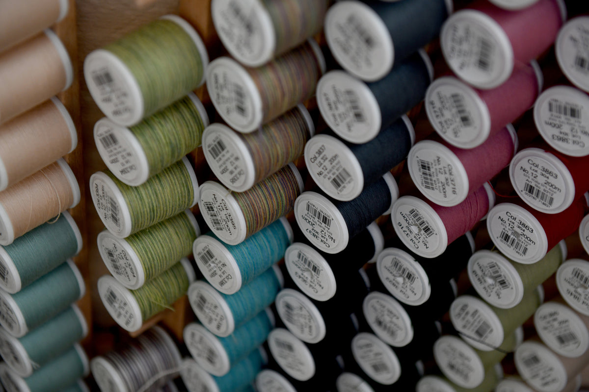 Bobines de fil colorées dans l’atelier Kouturissime pour les cours de couture