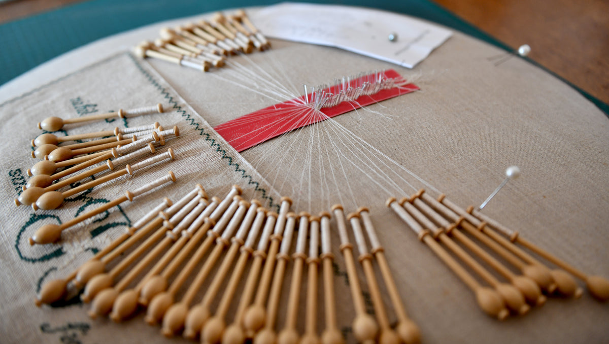 Dentelle aux fuseaux en cours de réalisation sur un métier à dentelle – cours à Guémené-Penfao