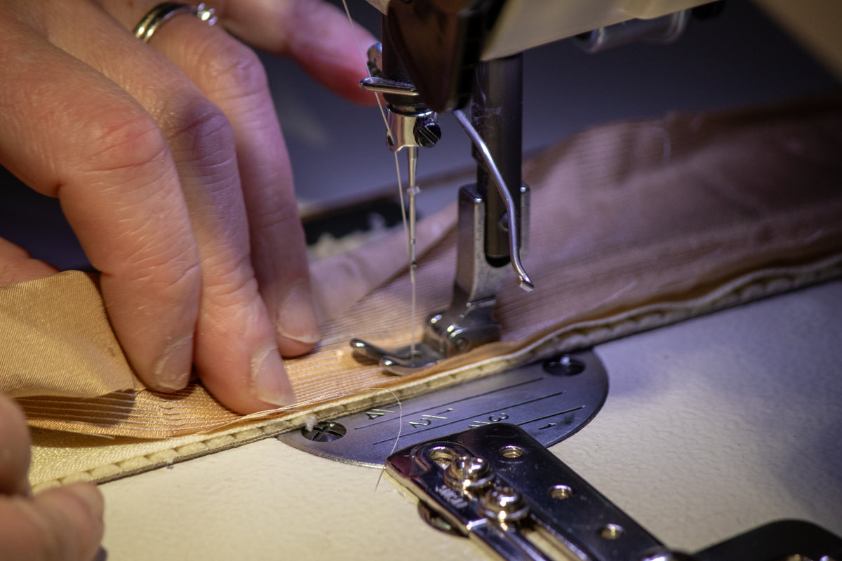 Travail de couture et retouche sur machine à coudre à l’atelier Kouturissime